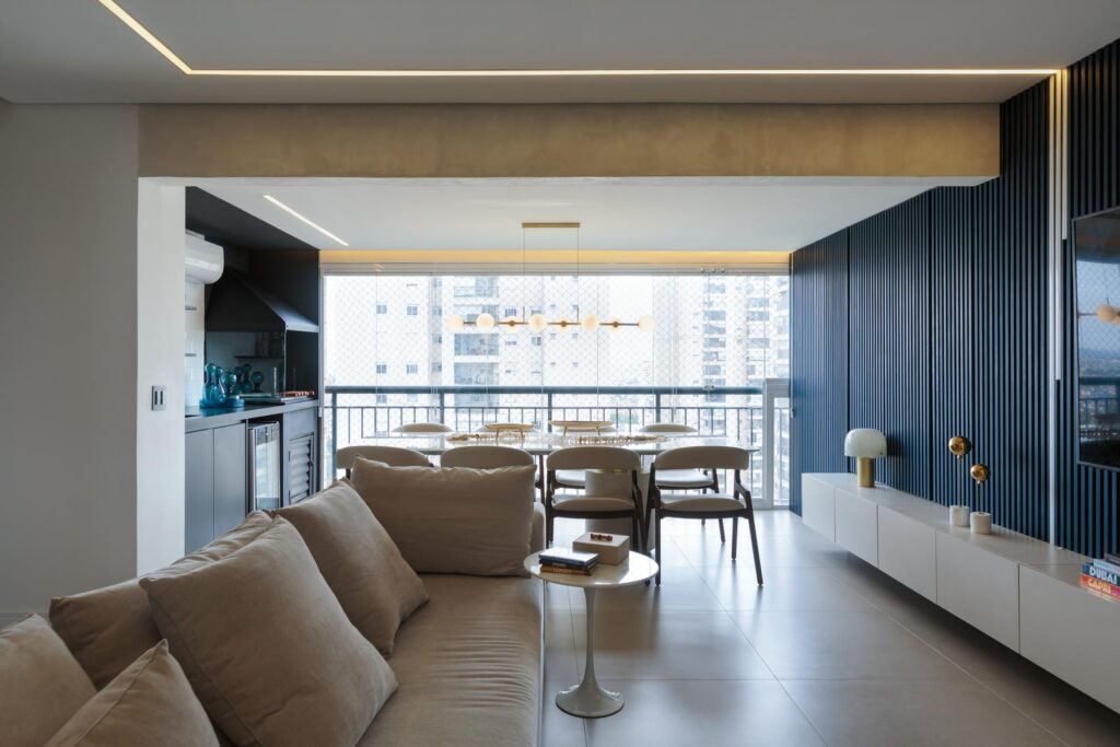 Sala de estar e jantar de apartamento de 130 m² com painel ripado azul e vista para a cidade