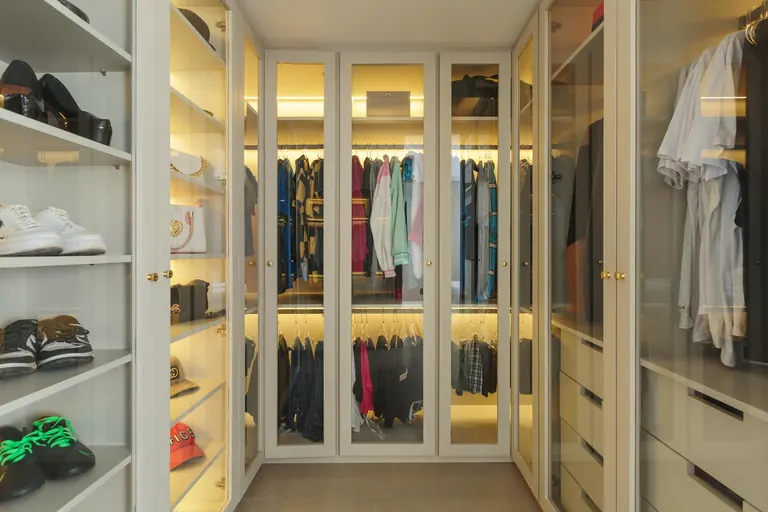 Closet com portas de vidro e iluminação embutida