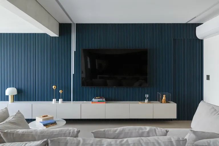 Painel ripado azul com TV na sala de estar